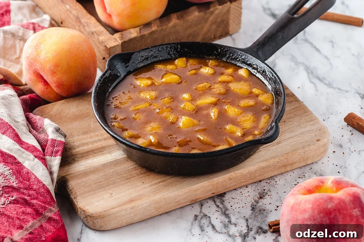 Sun-Kissed Peach Rice Pudding 4 A black iron skillet filled with bubbling, golden peach compote, ready to be served
