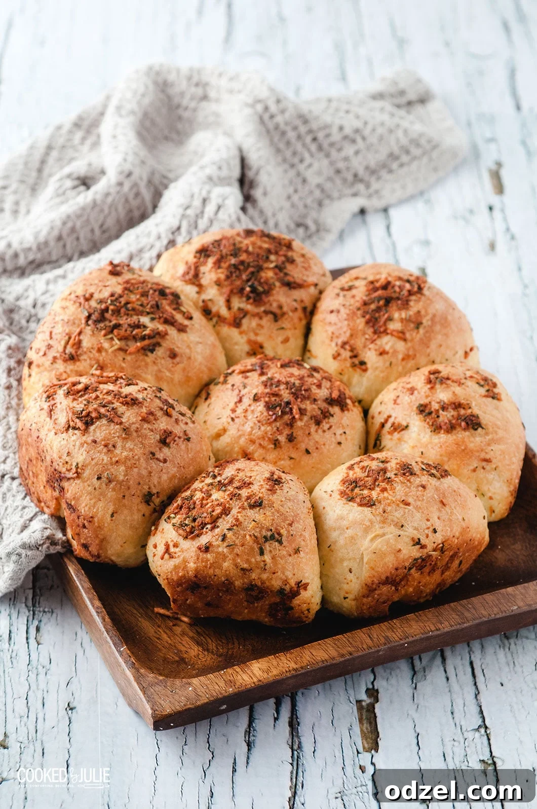 Ultimate Garlic Parmesan Dinner Rolls 2 Eight golden brown garlic parmesan dinner rolls arranged on a rustic wooden board, ready to be served