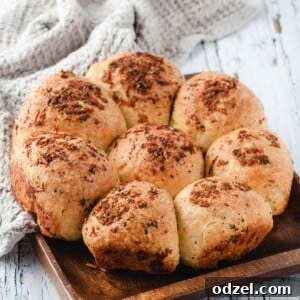 Ultimate Garlic Parmesan Dinner Rolls 5 Eight delicious garlic parmesan dinner rolls on a wooden board