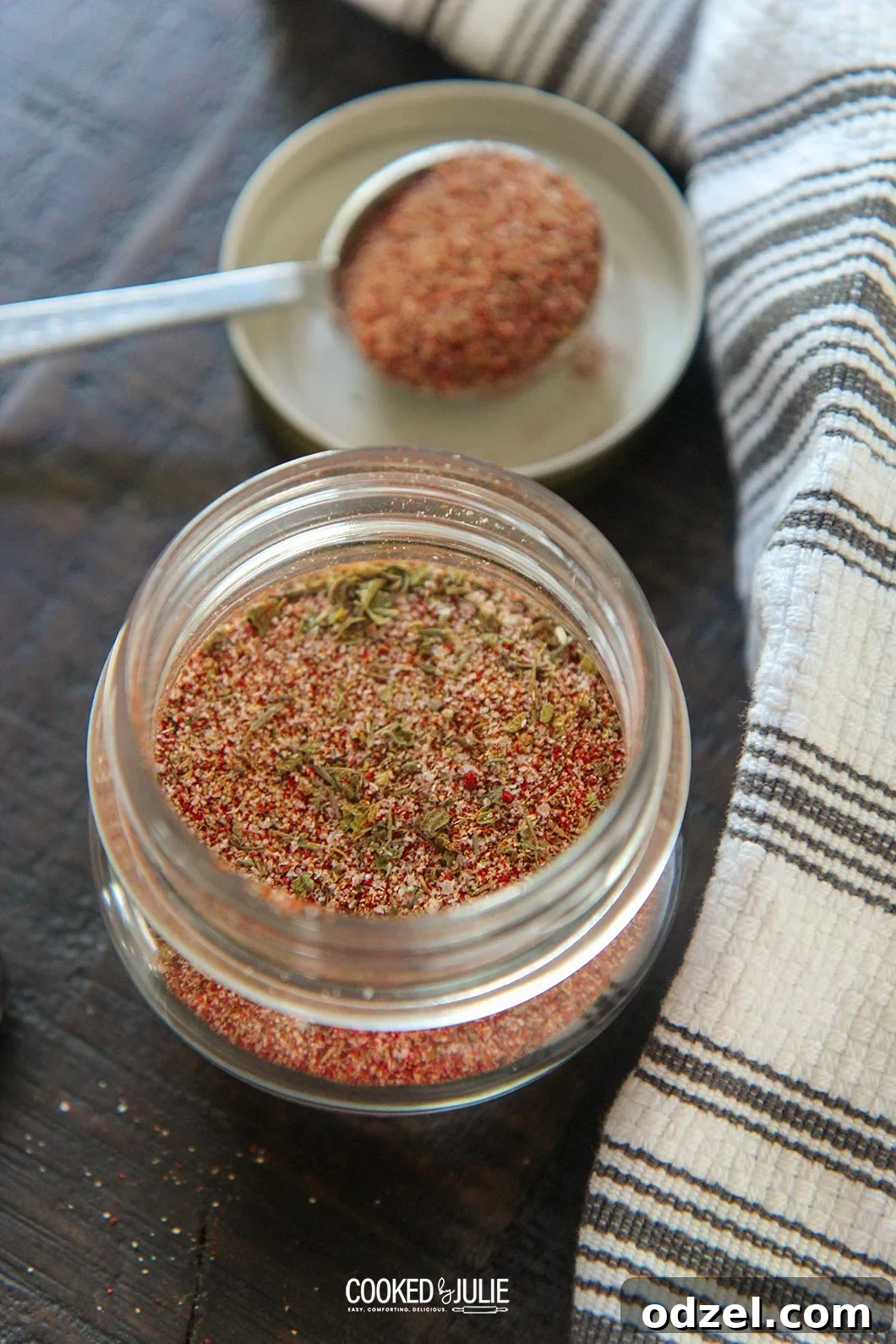 Louisiana's Fiery Spice Blend 2 Homemade Cajun seasoning blend in a small glass jar with a spoon, ready for use