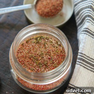 Louisiana's Fiery Spice Blend 5 Homemade Cajun seasoning blend in a small glass jar with a spoon