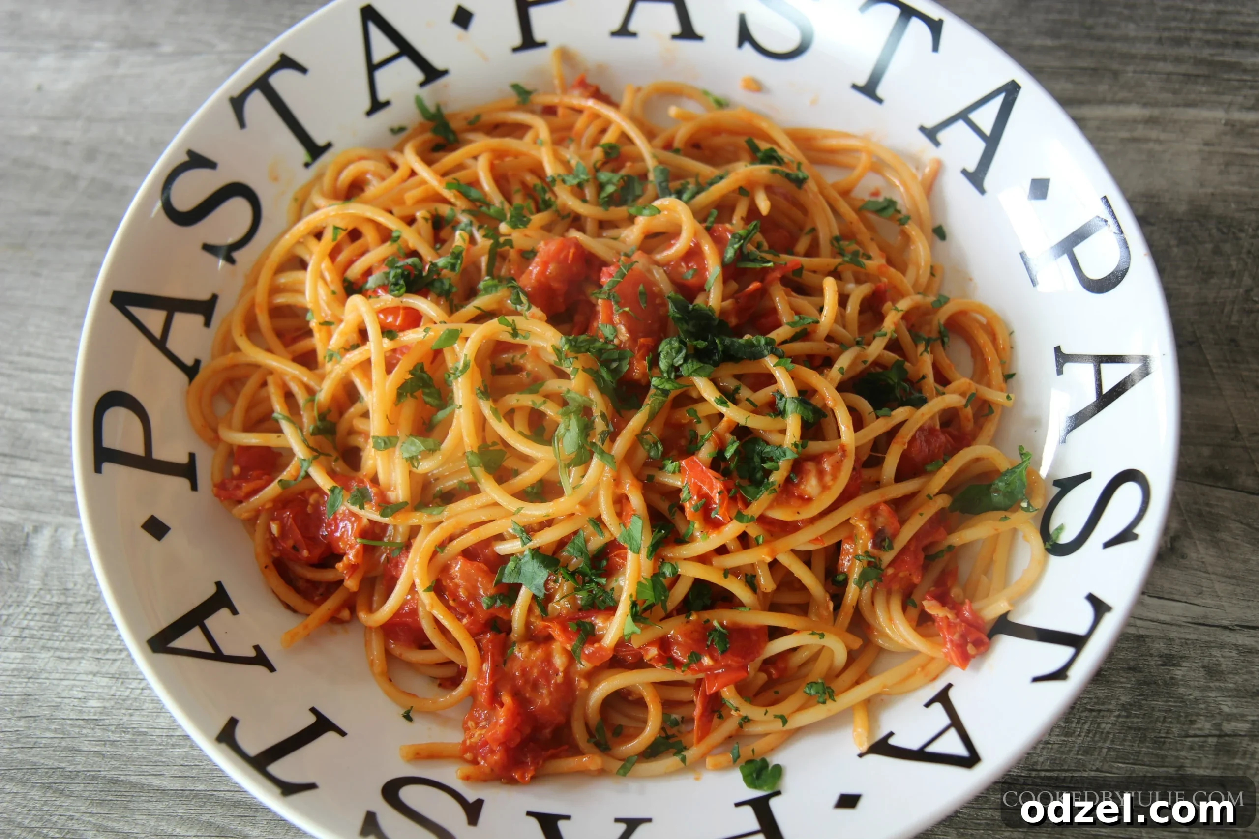 Close-up of Roasted Tomato Bucatini, highlighting the rich red color of the roasted tomatoes coated on bucatini pasta, with hints of cheese and fresh herbs.
