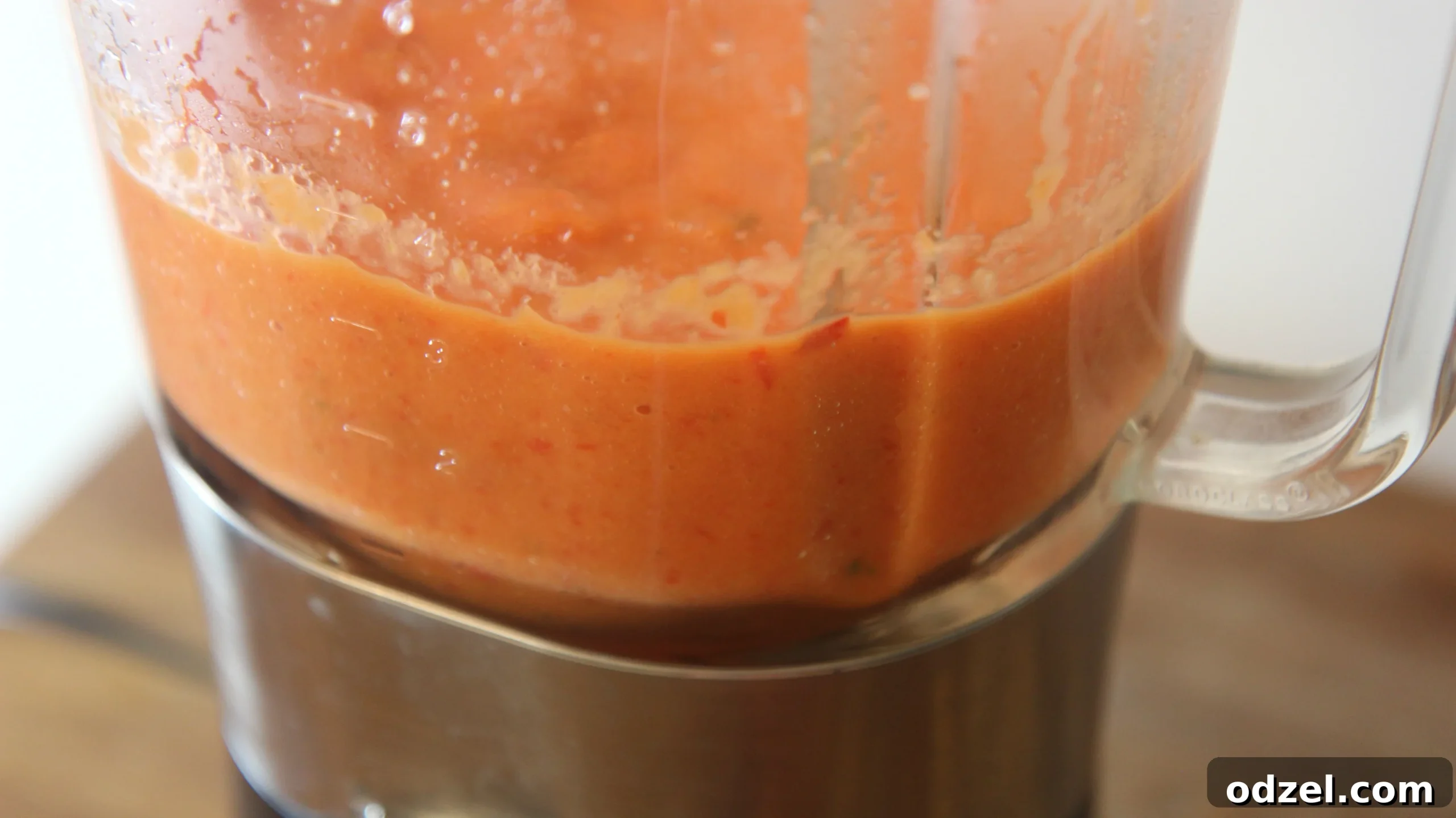 Smooth, vibrant red blended vegetable mixture in a blender, ready for the soup pot.