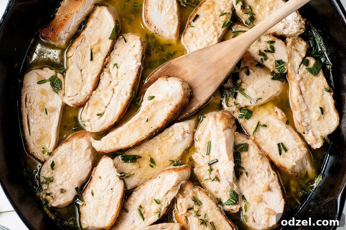 Savory Garlic Chicken with Spaghetti Squash 5 Sliced garlic Cajun chicken in a black skillet with a wooden spoon, coated in savory sauce.