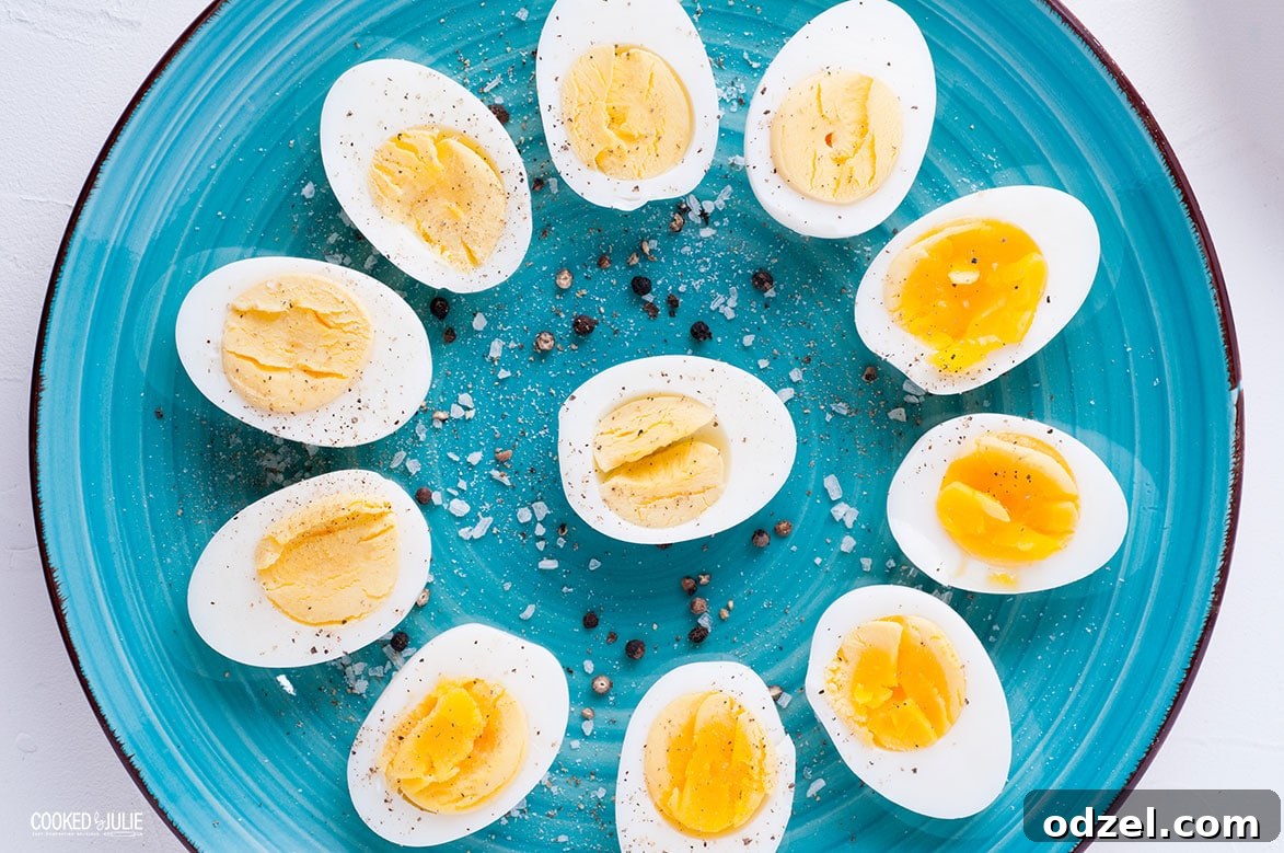 Sliced soft and hard cooked eggs arranged in a flower pattern and sprinkled with salt and pepper on a teal plate, showcasing versatility
