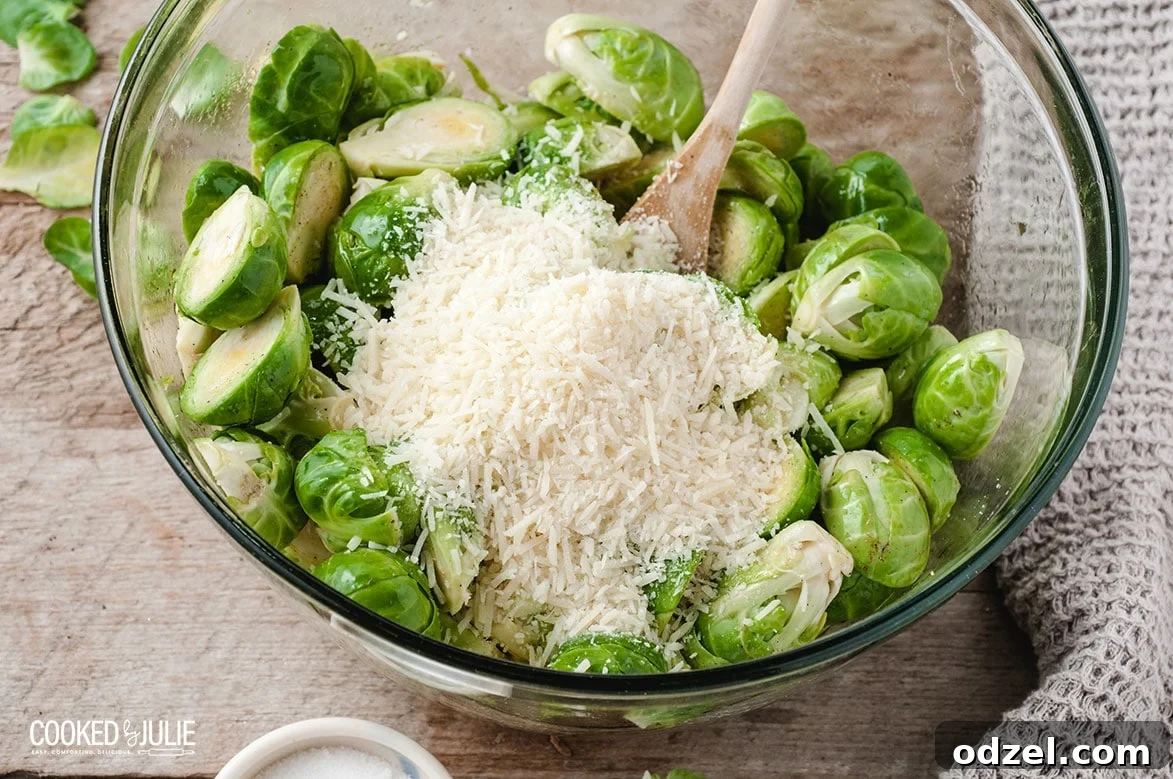 parmesan cheese and brussel sprouts with a wooden spoon in a bowl