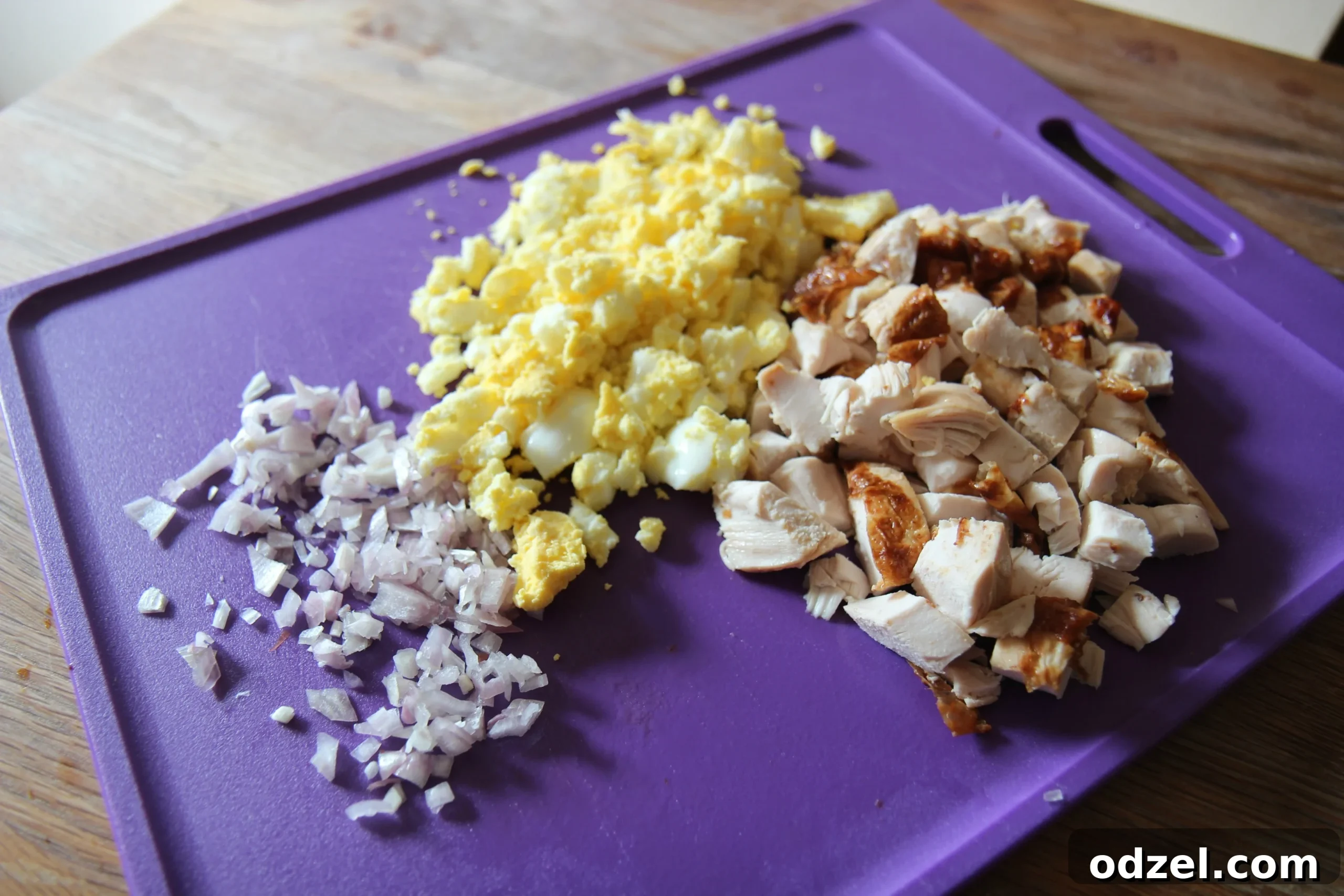 Diced onions, hard-boiled eggs, and cooked chicken are essential ingredients for a flavorful macaroni salad.