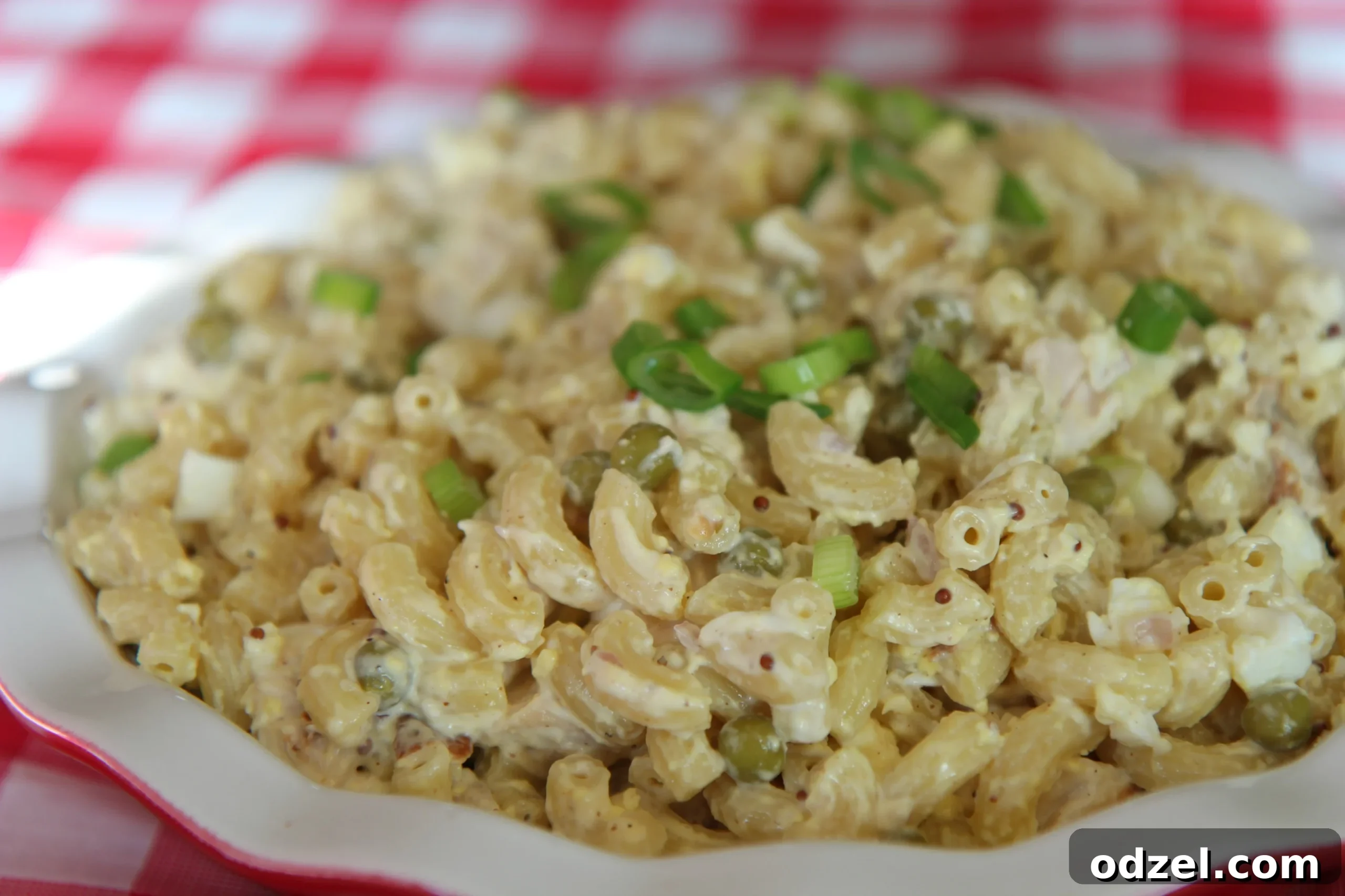 Close-up view of the creamy macaroni chicken salad sauce, highlighting the distinct grains of mustard.