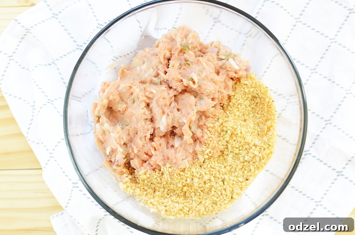 Zesty Salmon Burgers 4 Salmon burger mixture with breadcrumbs in a clear bowl, ready to be formed into patties.