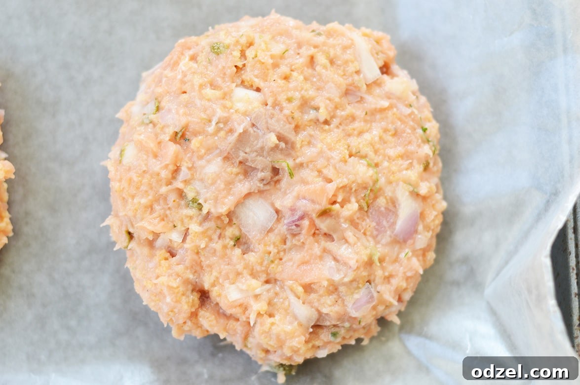 Zesty Salmon Burgers 5 Raw salmon burger patty, perfectly formed and ready for cooking.