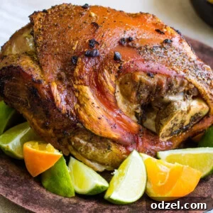 Roasted pork on a brown plate with limes and oranges