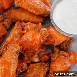 Baked buffalo wings on a gray plate with a side of bleu cheese