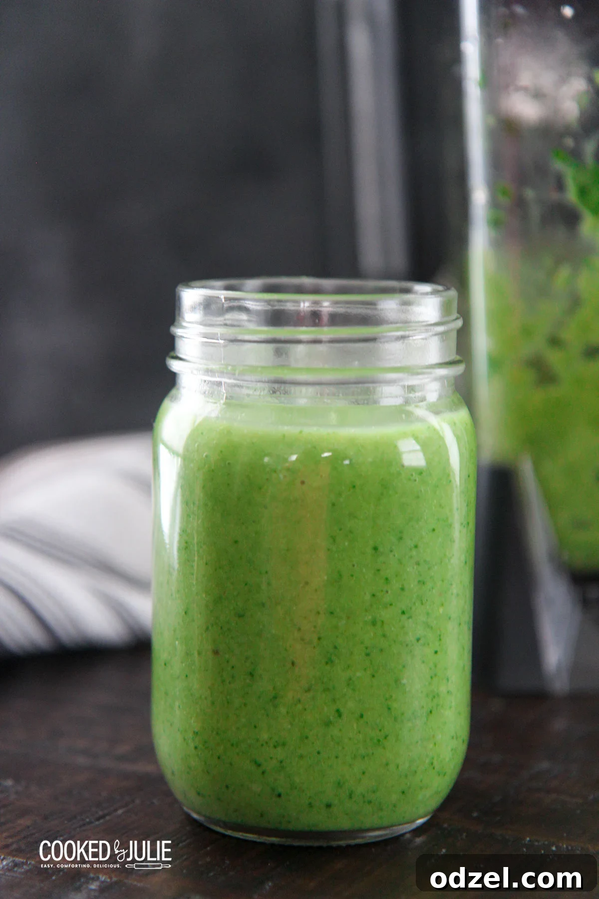 Vibrant spinach avocado green smoothie served in a clear mason jar with a straw, ready to drink.