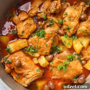 A vibrant Puerto Rican Pollo Guisado (Chicken Stew) with bone-in chicken, potatoes, and olives in a hearty sauce.