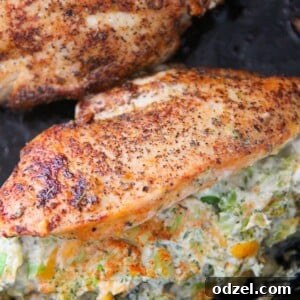 Two broccoli cheese stuffed chicken breasts in a cast iron skillet.