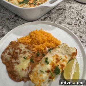 Green Chile chicken enchiladas with yellow rice and refried beans.