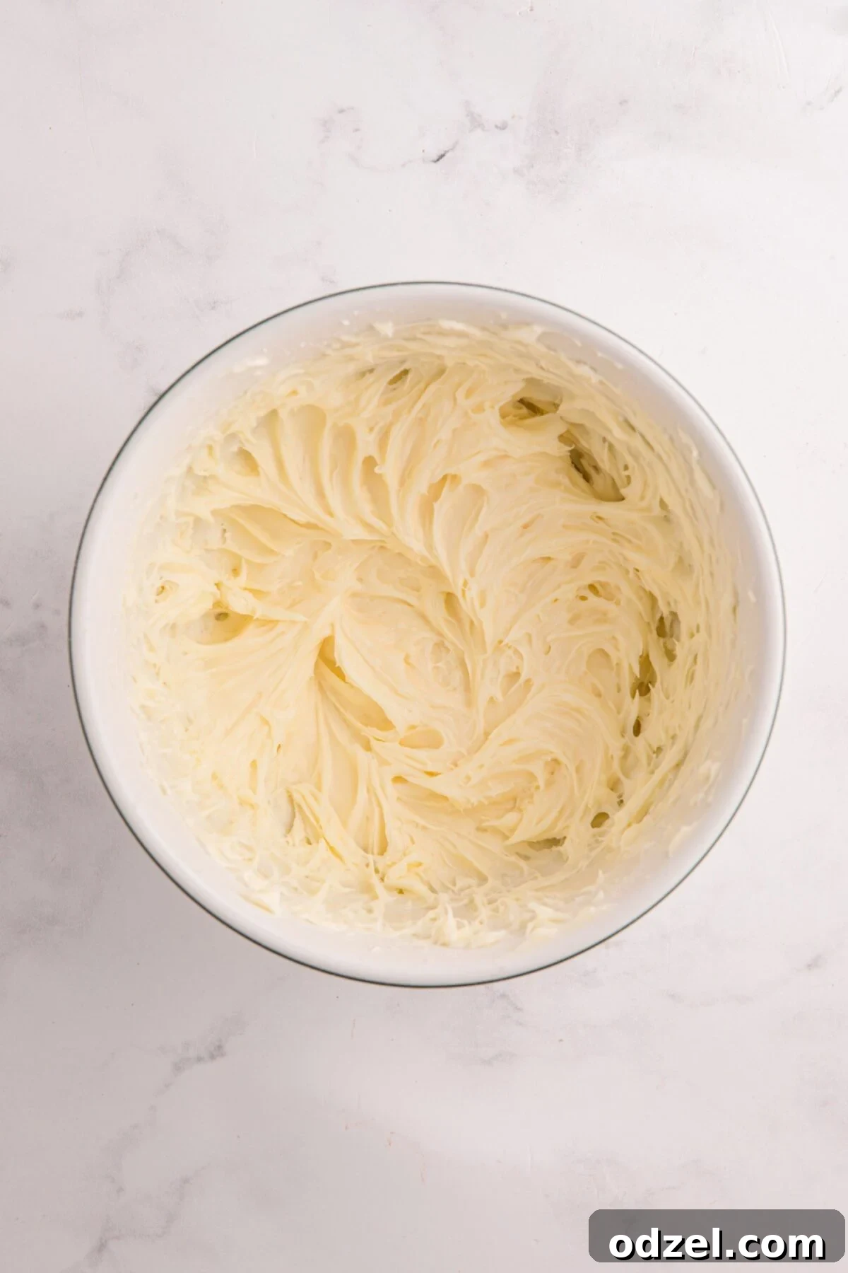 Cream cheese frosting in a white bowl. 