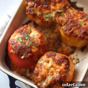 Four cheesy stuffed bell peppers filled with beef, cheese, and rice.