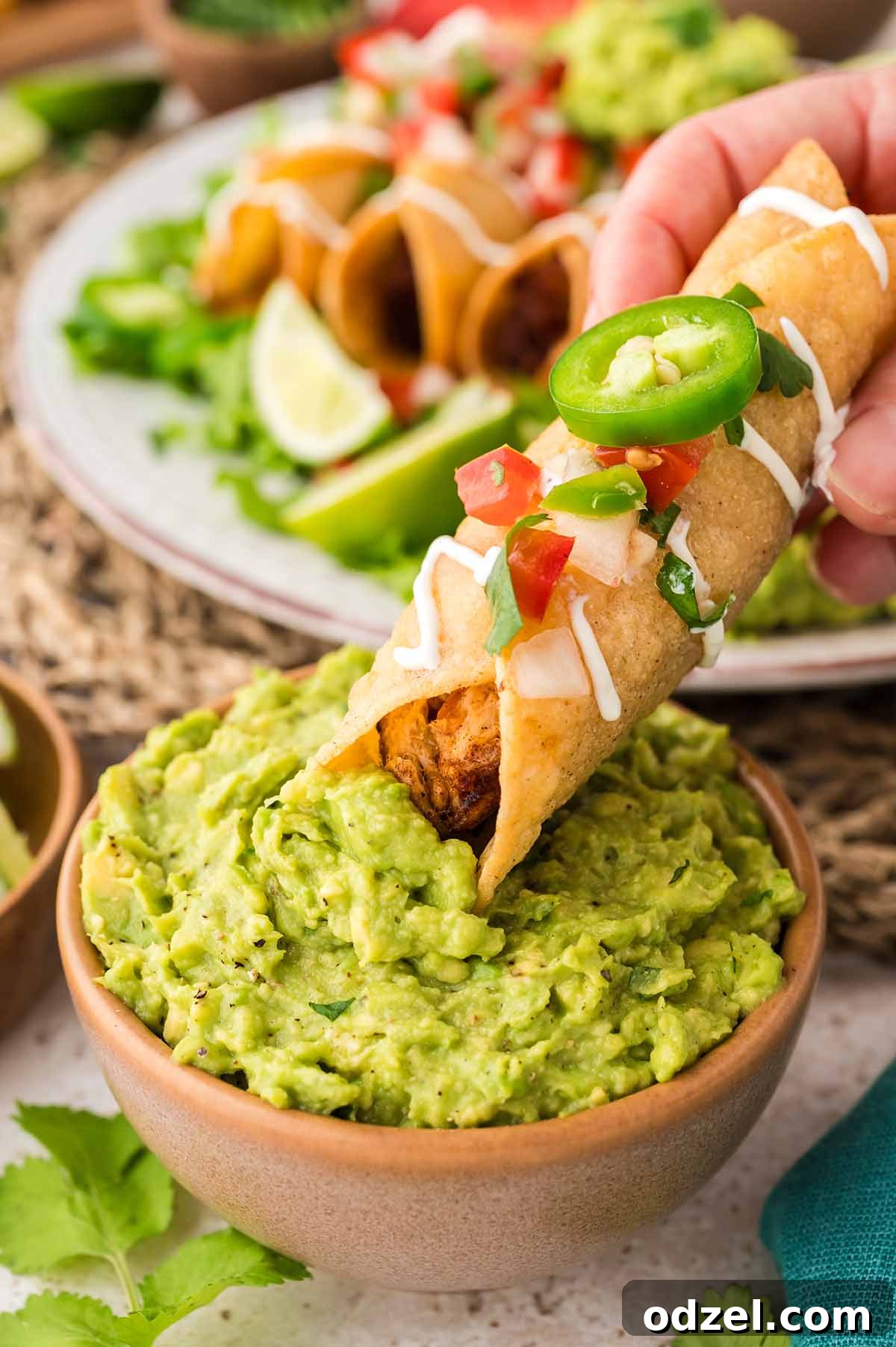 Smoky Chipotle Chicken Flautas 8 chicken flauta dipped in a bowl of guacamole.