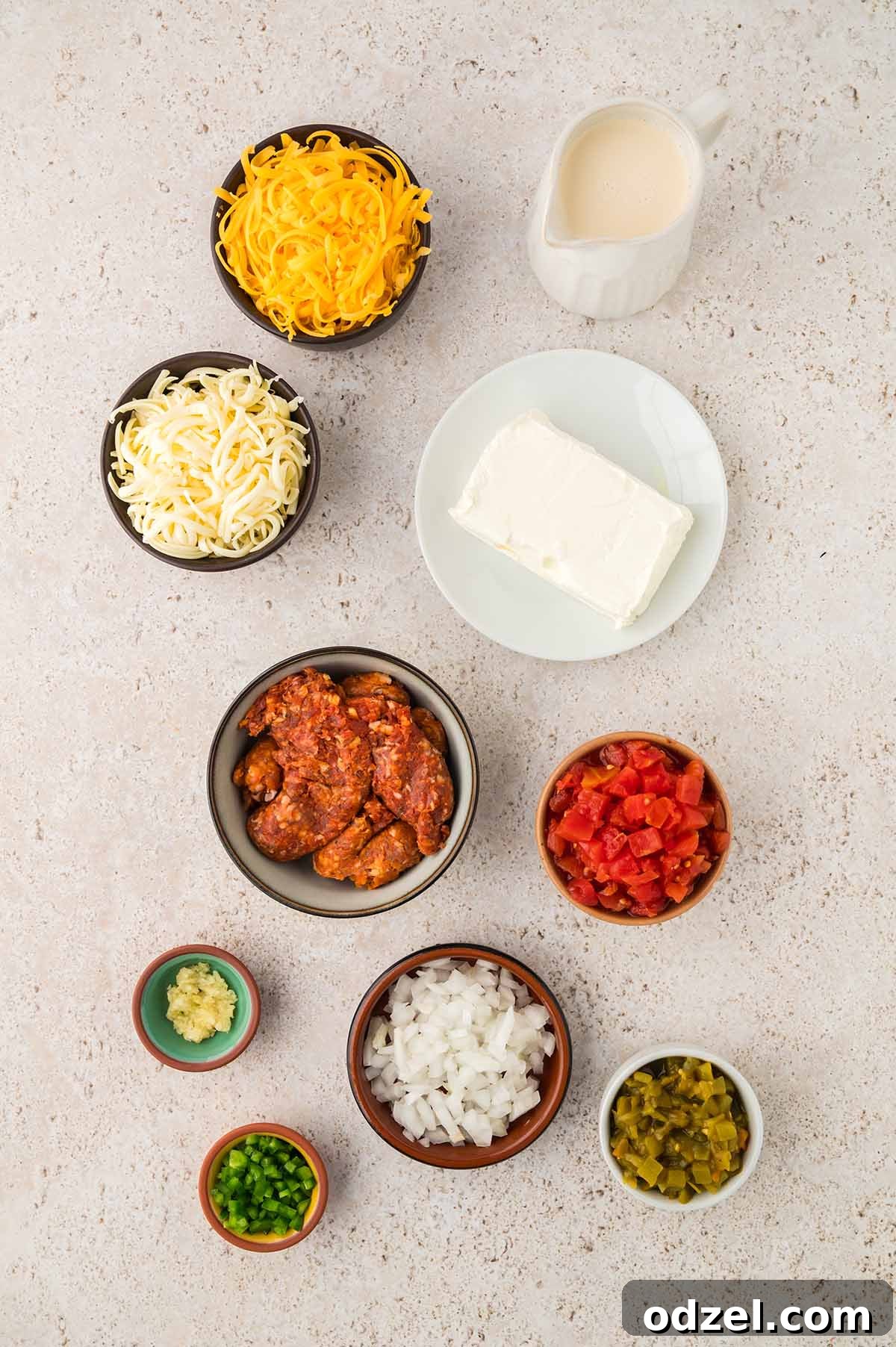 Melted Queso con Chorizo Dip Recipe for Parties 3 shredded cheese, cream cheese, raw chorizo, diced tomatoes, onions, garlic, peppers, and evaporated milk.