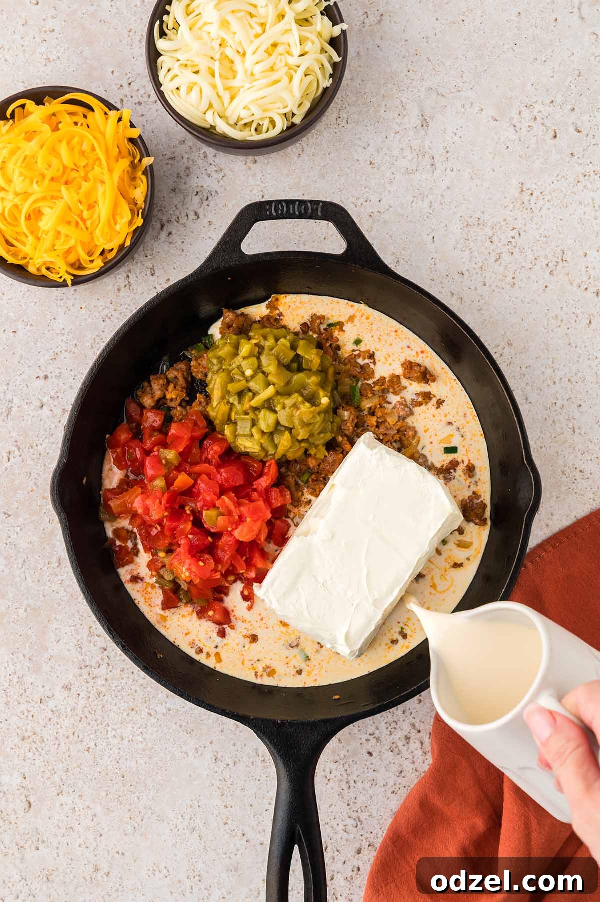 Melted Queso con Chorizo Dip Recipe for Parties 5 evaporated milk being poured into queso mixture.