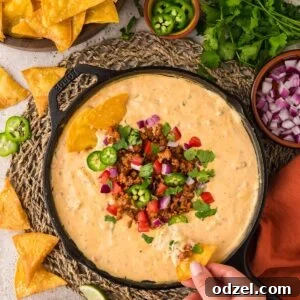 Melted Queso con Chorizo Dip Recipe for Parties 8 queso with chorizo, jalapeños, tomatoes, onions, and cilantro on top.