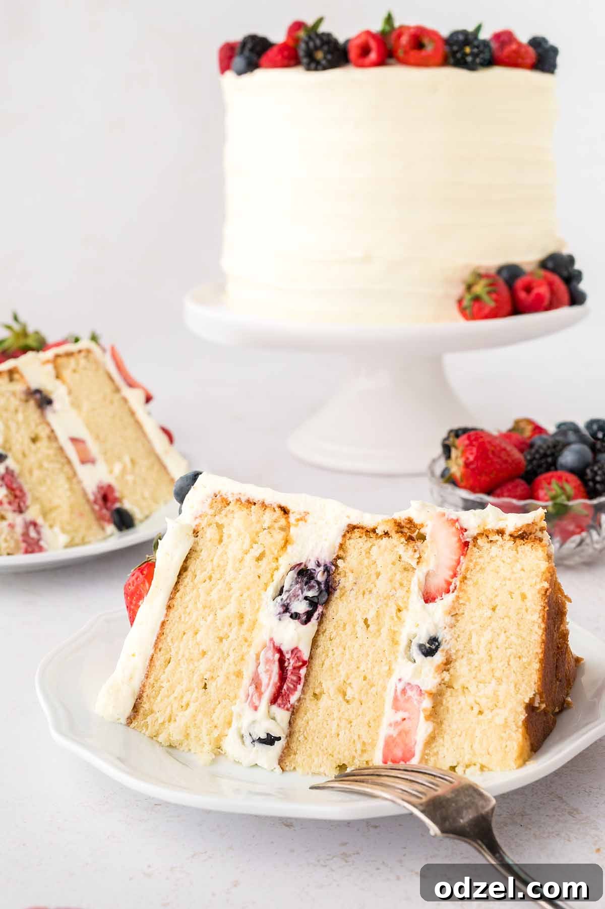 Light and Creamy Chantilly Cake Recipe for Special Occasions 11 Two slices of cake on plates and an entire cake in the background.