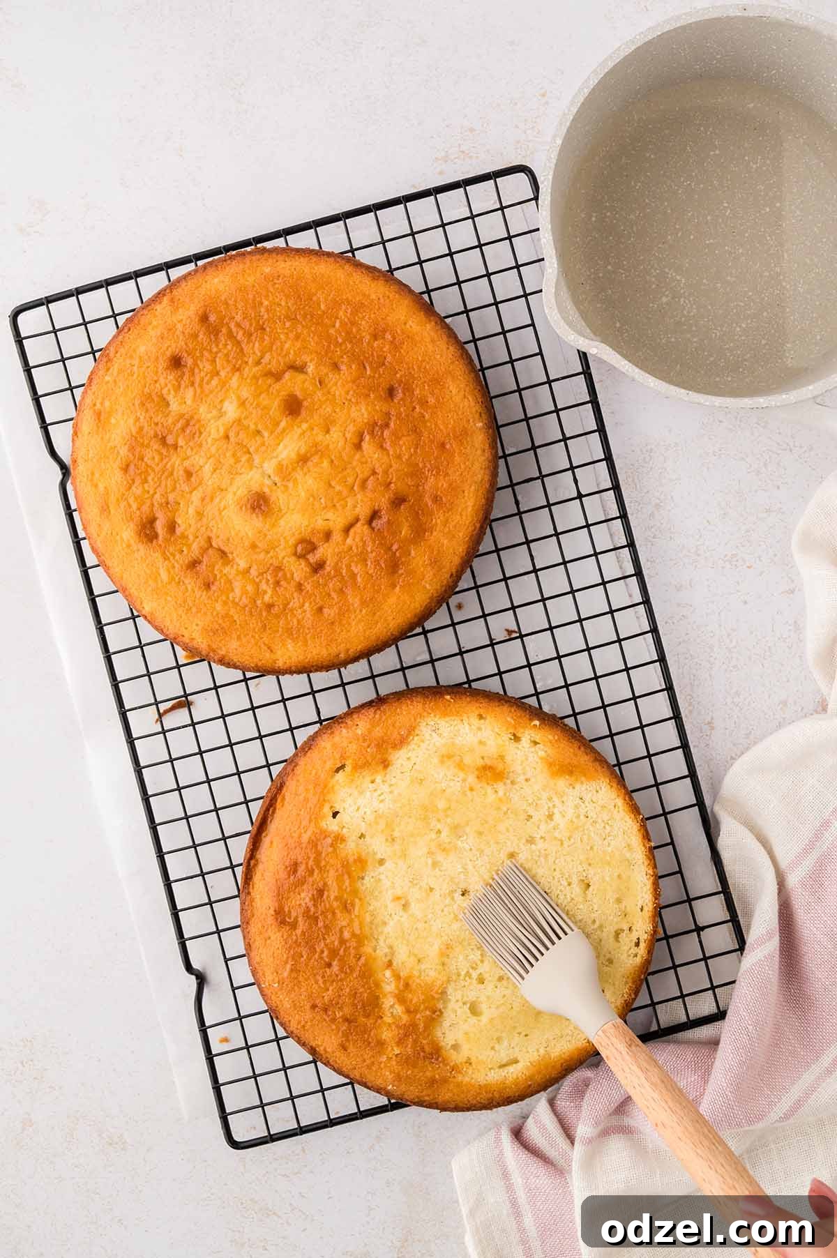 Light and Creamy Chantilly Cake Recipe for Special Occasions 6 Simple syrup being brushed over the cake layers.