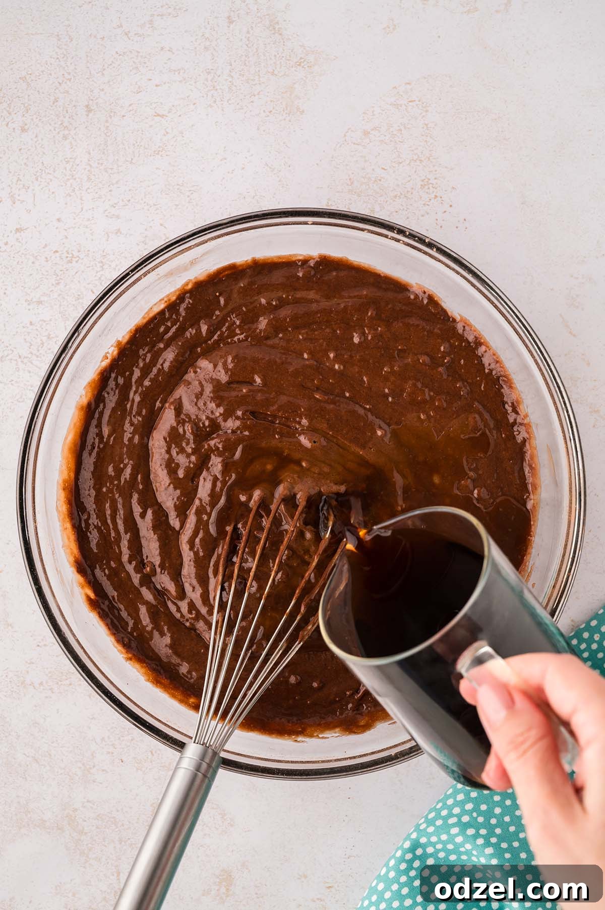 Copycat Dot Cakes Recipe: Make Classic Mini Cake Bites at Home 5 Coffee being poured into a bowl of chocolate cake batter.