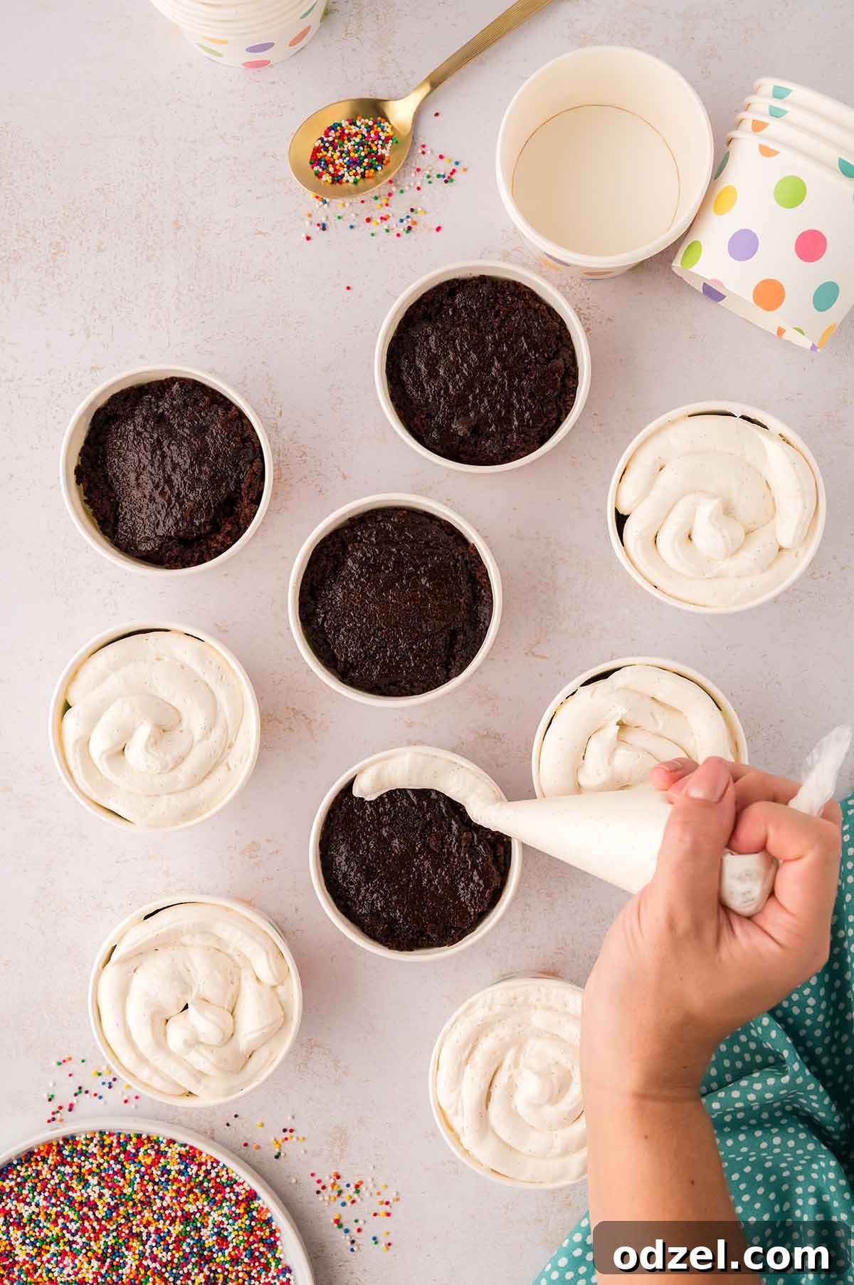 Copycat Dot Cakes Recipe: Make Classic Mini Cake Bites at Home 8 Hand piping frosting into cake cups with a piping bag.