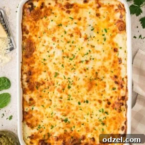 Creamy Pesto Chicken Lasagna Recipe 11 Baked white chicken lasagna with fresh parsley on top.
