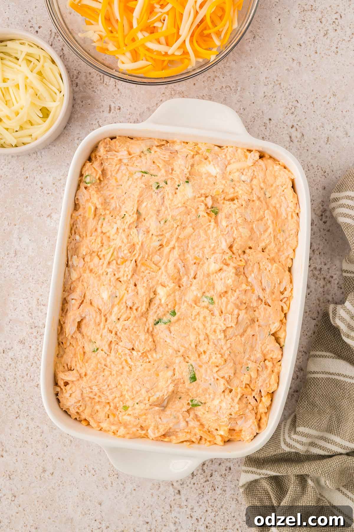 Classic Buffalo Chicken Dip Recipe 5 Buffalo chicken dip in a white baking dish with cheese on the side.