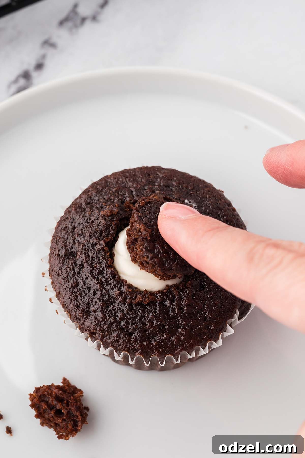 Gooey Marshmallow-Filled Chocolate Cupcakes 6 Placing the cut-out piece of cupcake back on top to cover the filled center.
