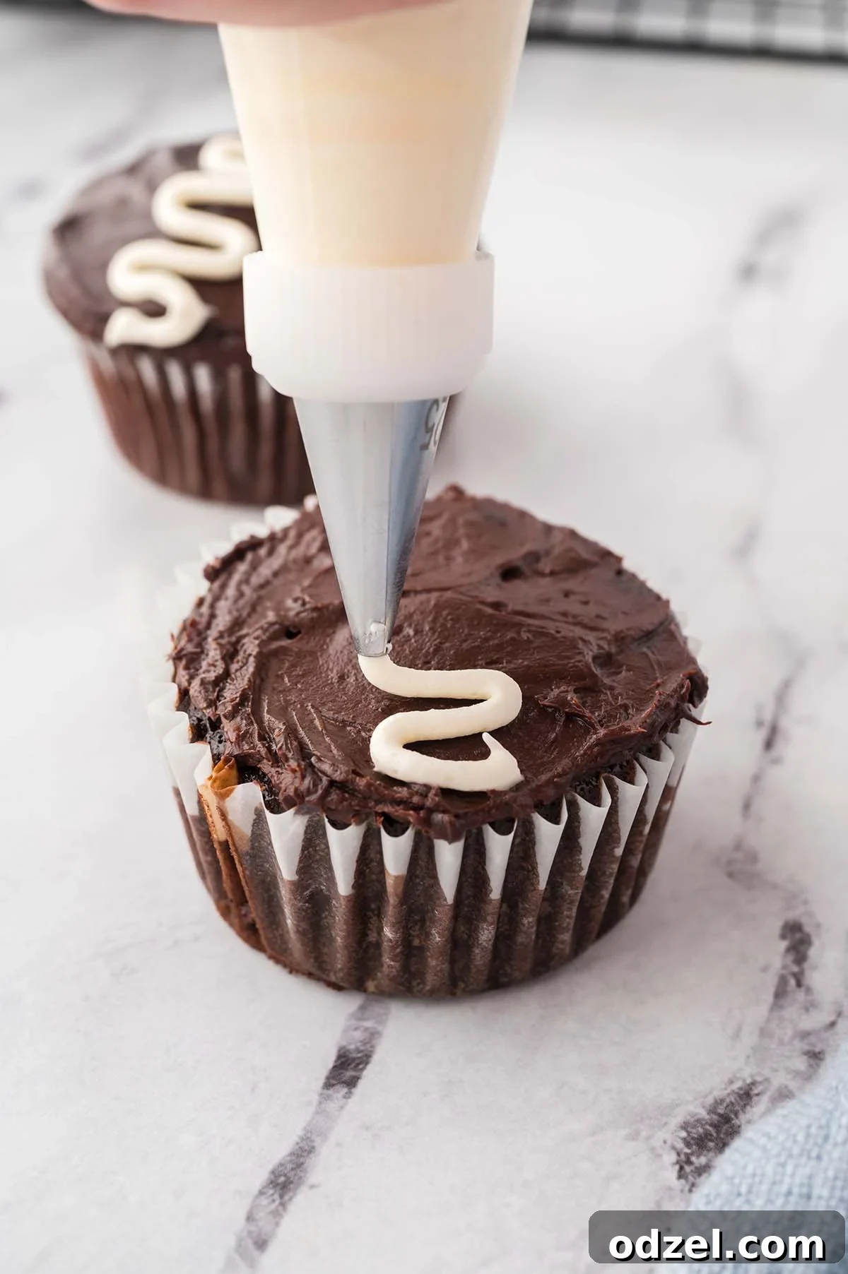 Gooey Marshmallow-Filled Chocolate Cupcakes 7 a piping bag to piping the signature white swirly line across the top of the cupcake.