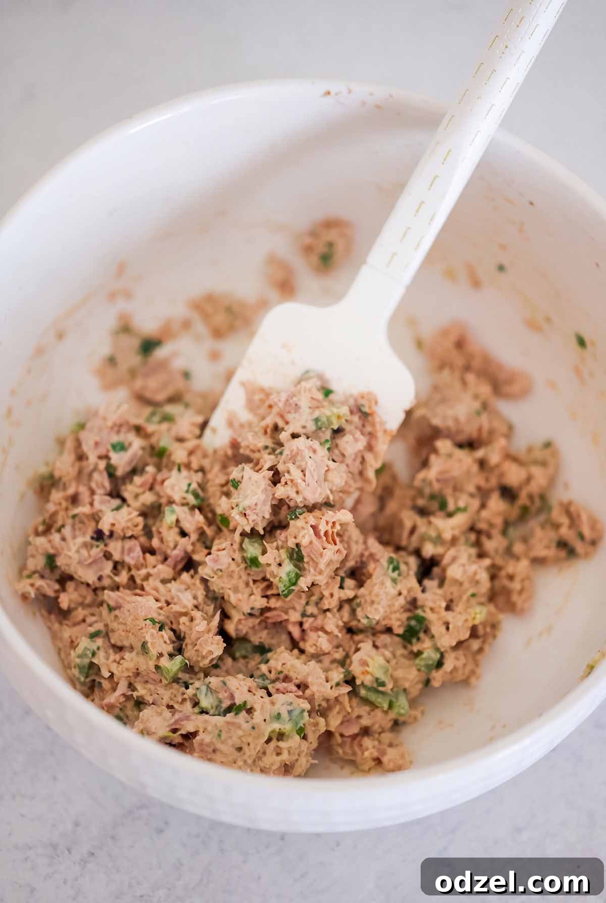 Crispy Spicy Tuna Melt with Sriracha Aioli 4 Tuna salad and a rubber spatula in a white bowl.