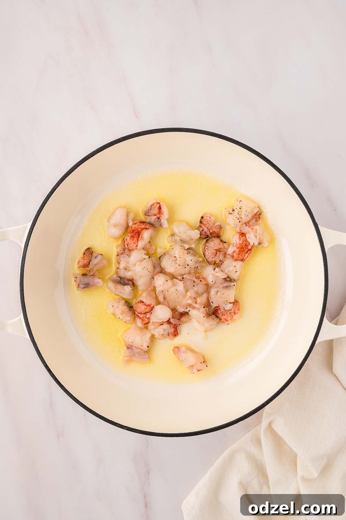 Creamy Lemon Garlic Lobster Orzo Recipe 4 raw lobster tail chunks cooking in oil and butter.