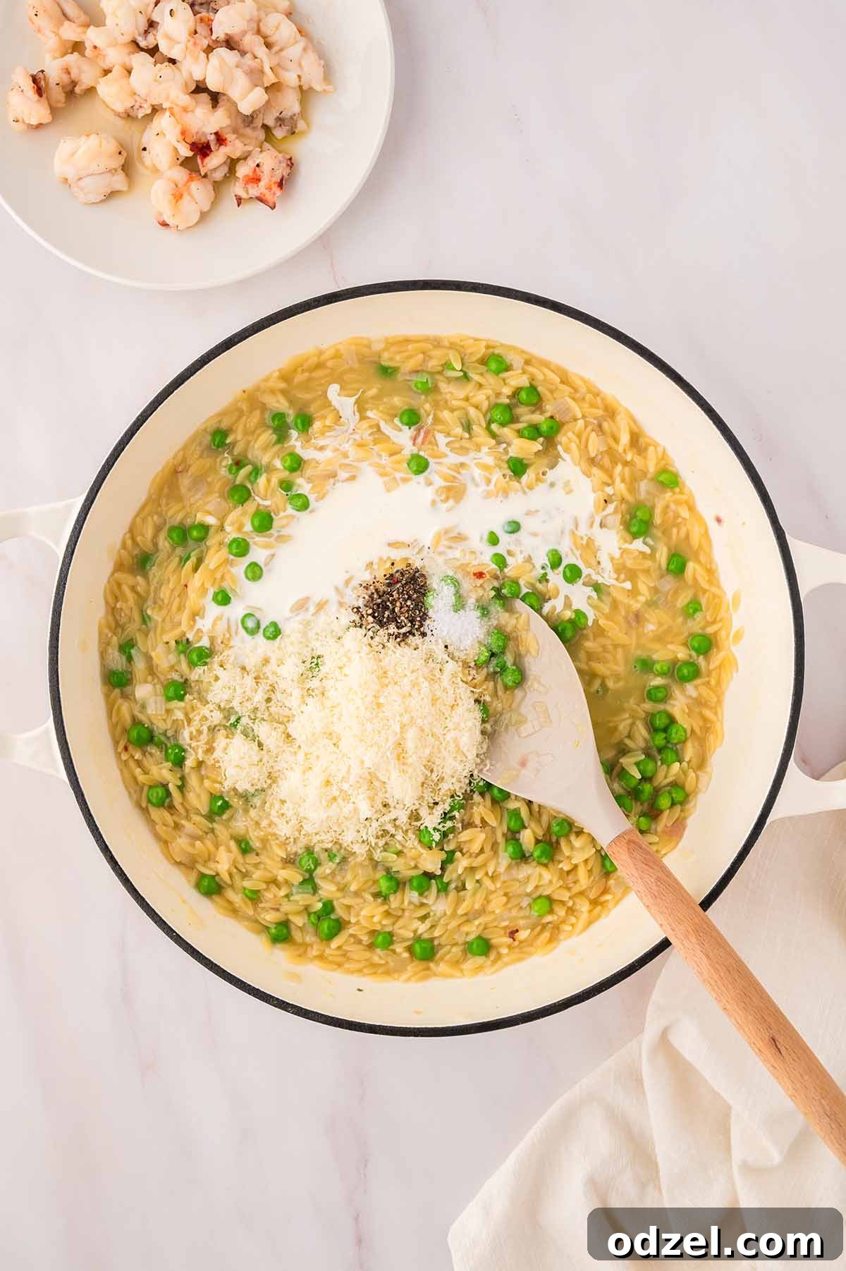 Creamy Lemon Garlic Lobster Orzo Recipe 7 creamy orzo with parmesan and spices on top with cooked lobster meat on the side.