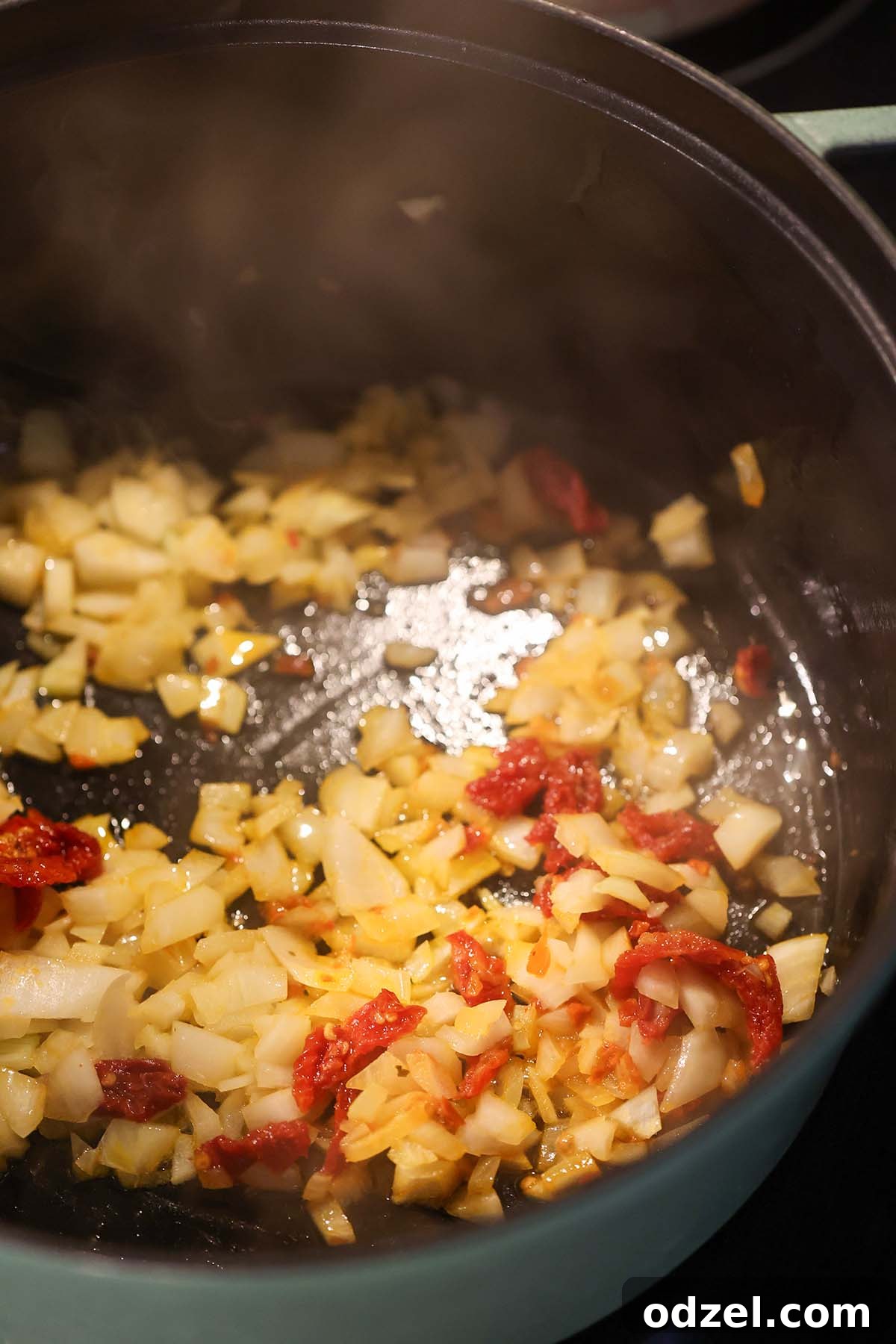 Comforting Chicken, Tomato and Lentil Soup Recipe 3 onions and sun dried tomatoes sautéing in a pot.