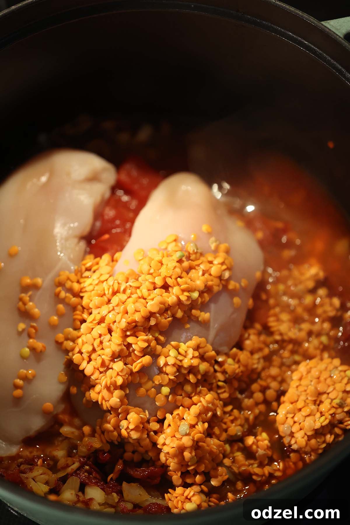 Comforting Chicken, Tomato and Lentil Soup Recipe 4 raw chicken breasts, raw lentils, and chicken stock in a pot.