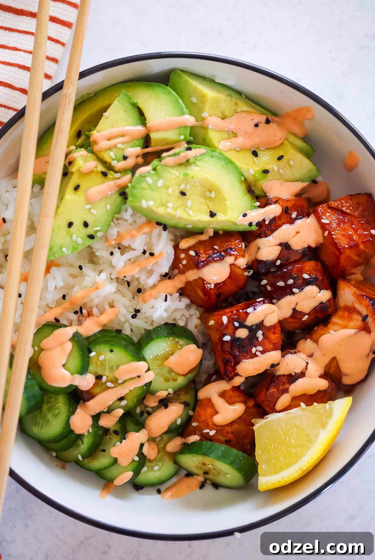 Salmon and Avocado Rice Bowls with Sesame Soy Dressing 2 salmon avocado rice bowl with chopsticks.